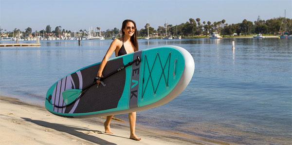Woman Carrying PEAK SUP Down the Beach by Center Handle