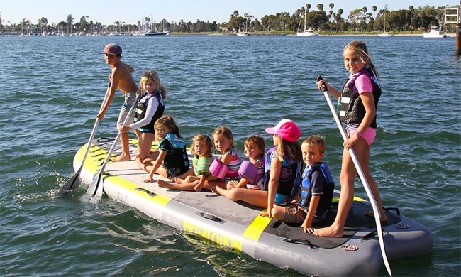 Isle Megalodon Inflatable SUP with 9 Kids Paddling on It